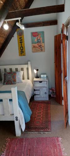 a bedroom with a bed and a table with a night stand at StarFish Accommodation in Struisbaai
