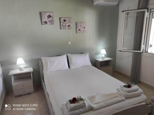sypialnia z białym łóżkiem i 2 szafkami nocnymi w obiekcie Aglaia House w Korfu