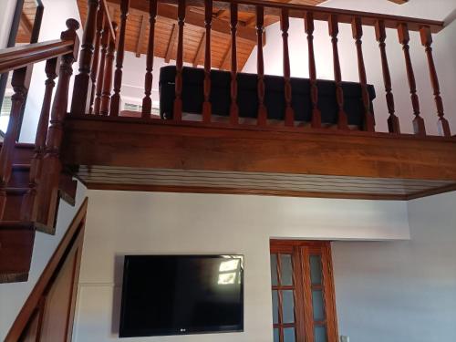 a living room with a staircase with a flat screen tv at Casa Azul em Chaves in Chaves