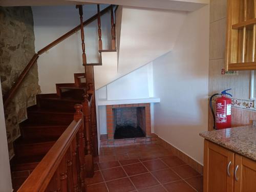 a staircase in a kitchen with a fire place at Casa Azul em Chaves in Chaves