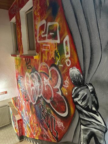 a painting of a person on a wall with graffiti at Mike‘s Mosel Lodge in Treis-Karden