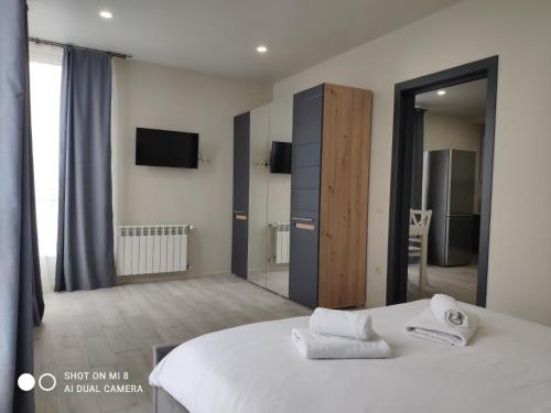 une chambre avec un lit blanc et une chambre avec une télévision dans l'établissement Apartments Domovik Миру 11с /11, à Moukatcheve