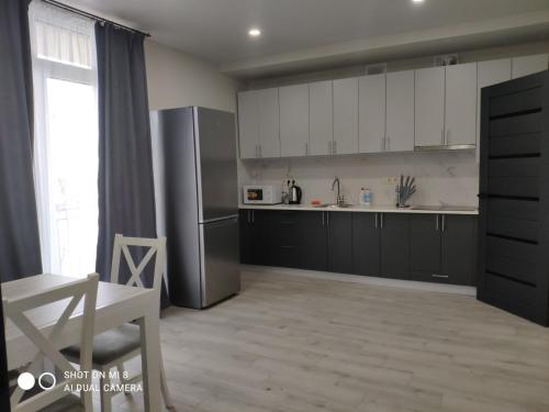 - une cuisine avec des armoires en noir et blanc et un réfrigérateur dans l'établissement Apartments Domovik Миру 11с /11, à Moukatcheve