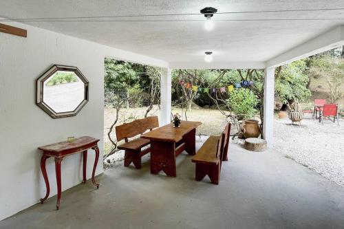eine Terrasse mit einem Tisch, Bänken und einem Spiegel in der Unterkunft Idyllische Ferienwohnung zwischen Meer und See in Punta del Este