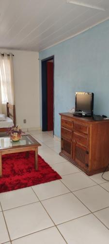uma sala de estar com uma televisão e uma mesa de centro em Casa Vista para Serra em Tiradentes