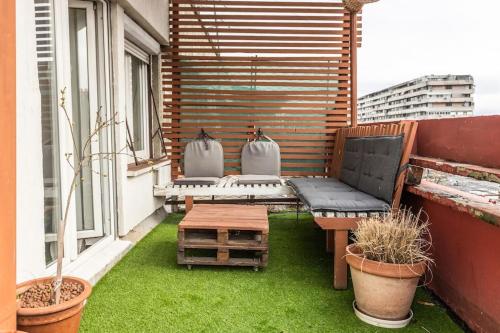 a small patio with a bench and a table on a balcony at Lovely Studio with a big terrace in Belgrade