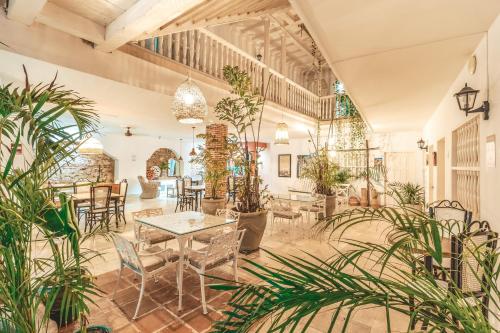 Habitación grande con mesas, sillas y plantas. en Hotel Kartaxa en Cartagena de Indias