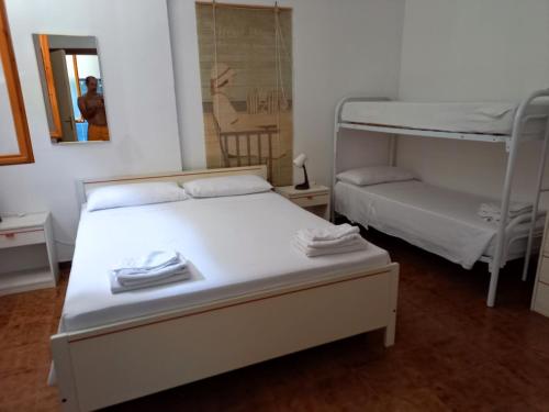 a bedroom with two bunk beds and a mirror at Baia Santa Maria in Cittadella del Capo