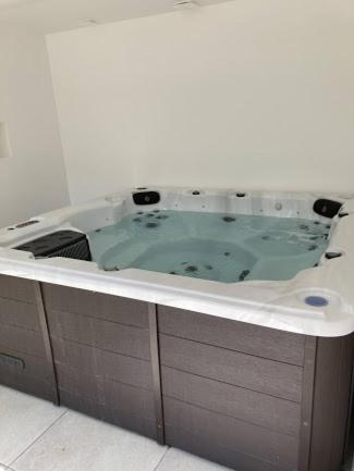 y baño con bañera y lavamanos. en Gîte tout confort (SPA, Sauna, piscine chauffée), en Saint-Vivien