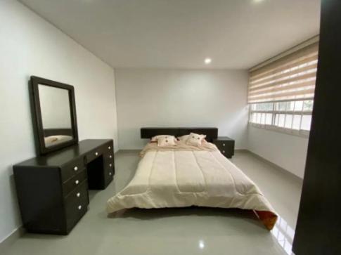 1 dormitorio con cama, tocador y espejo en Acogedora casa muy cerca al centro histórico de Popayán, en Popayán