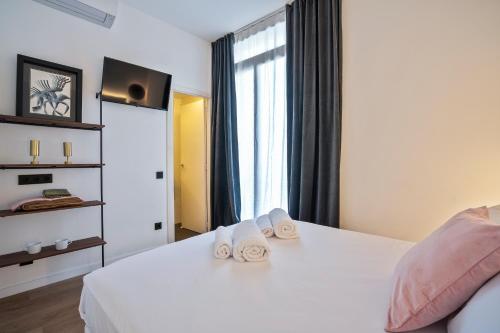 a bedroom with a white bed with towels on it at Hotel Casa Trafalgar Barcelona in Barcelona