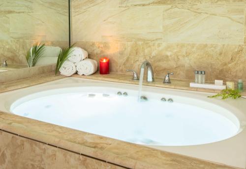 a bath tub with a red candle in a bathroom at New Gardena Hotel in Gardena