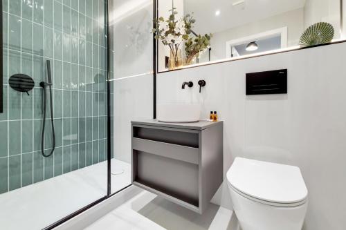 a bathroom with a shower and a toilet and a sink at Deluxe Harrow Wembley Apartment in Harrow