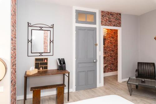une pièce avec une porte, une table et un miroir dans l'établissement La Ferblanterie, à Rambervillers