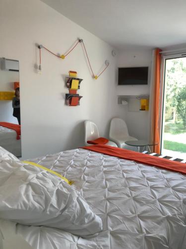 Un dormitorio con una cama grande y una ventana en La Maison 1440, en LʼIsle-sur-la-Sorgue