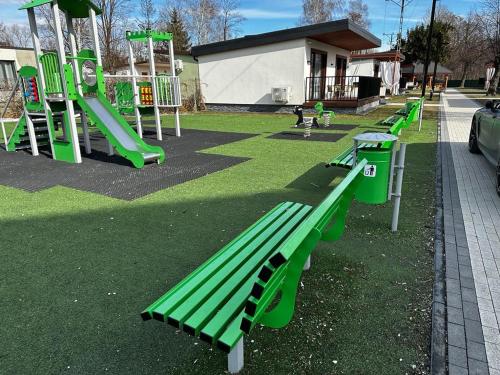 a park with green benches and a slide at WRZOS resort & wellness in Węgierska Górka