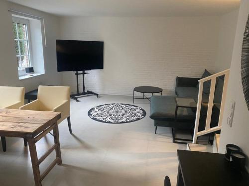 een woonkamer met meubilair en een flatscreen-tv bij Hof Busen Malibu in Mönchengladbach