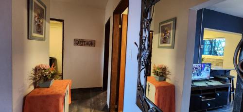 a hallway with two tables with flowers on them at Ivy House Apart Hotel in Ciudad del Este