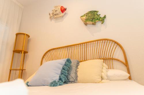 um quarto com uma cama com uma cabeceira de madeira em Casa El Lance - Patio y Paseo Marítimo em Barbate