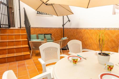 einen Tisch und Stühle mit Sonnenschirmen in einem Restaurant in der Unterkunft Casa El Lance - Patio y Paseo Marítimo in Barbate