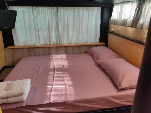 1 cama rosa grande en una habitación pequeña en terrebioBus, en Visnadello