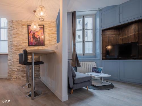 ein Wohnzimmer mit einem Tisch und einem Stuhl in der Unterkunft LE VIEUX LAVAL in Laval