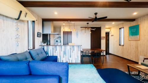 a living room with a blue couch and a table at Ocean Villa Vihara ヴィハーラ in Ōda