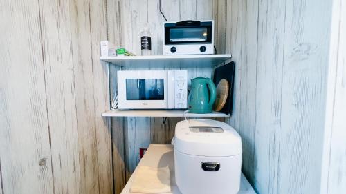 a small kitchen with a microwave and a toaster at Ocean Villa Vihara ヴィハーラ in Ōda