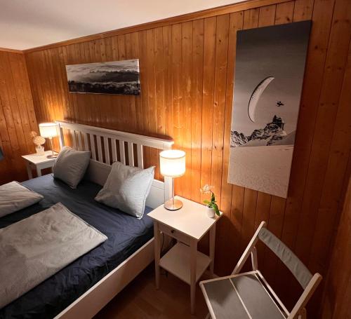 a bedroom with a bed and a table with a lamp at CLOUD No3, Interlaken in Matten