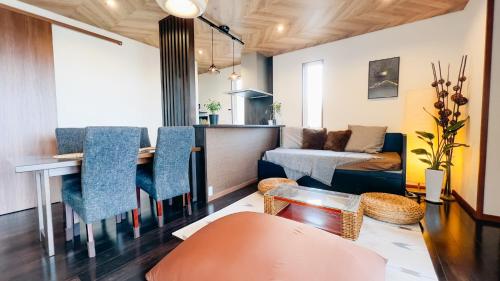 a living room with a table and chairs and a couch at Ocean Villa Vihara ヴィハーラ in Ōda