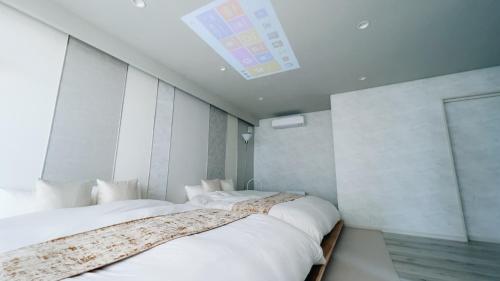 a bedroom with two beds and a skylight at Ocean Villa Vihara ヴィハーラ in Ōda