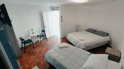 Habitación con 2 camas, mesa y sillas en Hotel Flamingo Express, en Iquique