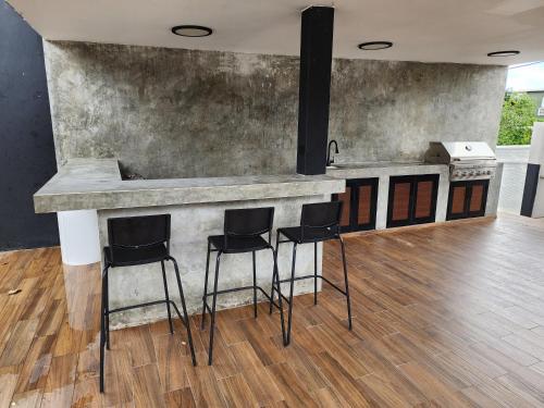 a kitchen with a bar with stools around it at Casa Delizia close to everywhere! in San Juan
