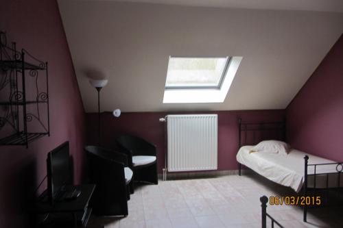 a bedroom with a bed and a skylight at Auberge de la Lesse in Celles