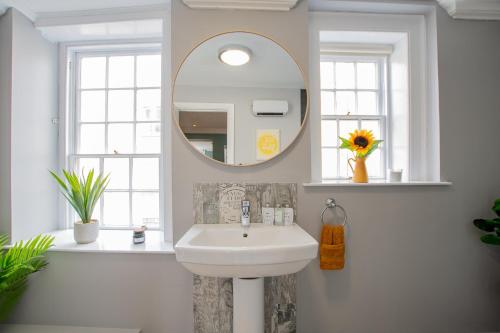 a white bathroom with a sink and a mirror at The Yellow Door by Shortstays in Dublin