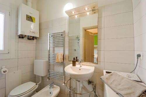 a white bathroom with a sink and a toilet at Il Gattino di Sanremo - Trilocale centro e stazione del treno in Sanremo