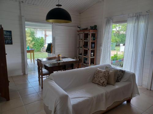 Vila Eco SPA في أراكاجو: غرفة معيشة مع أريكة بيضاء وطاولة
