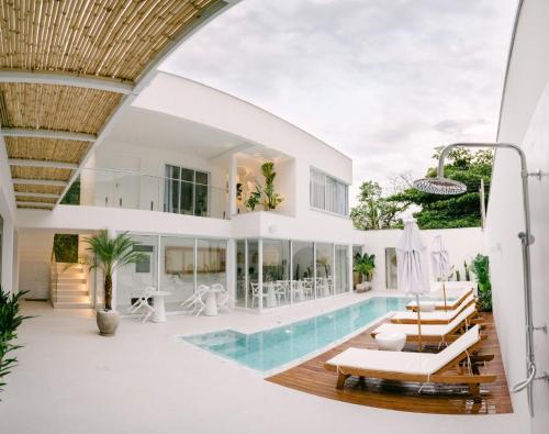 una sala de estar abierta con piscina y una casa en Olisa Hotel Boutique, en Maresias