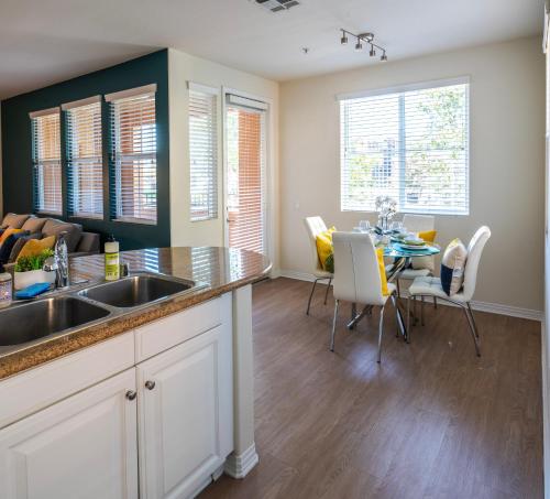 a kitchen with a sink and a table with chairs at Amazing 2 bedroom 7 min from Disneyland w FREE Parking in Anaheim
