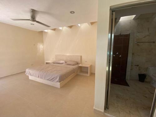 1 dormitorio con 1 cama y ducha a ras de suelo en cocay house, en Uaymitun