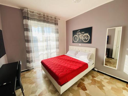 a bedroom with a bed with a red blanket and a mirror at Milano relax family house in Brugherio