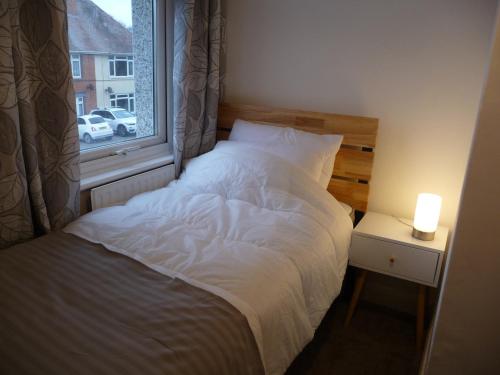 Ce lit se trouve dans un dortoir doté d'une fenêtre. dans l'établissement Bright spacious home, enclosed garden & parking, à Hindlip