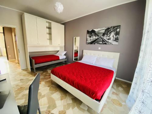 una camera con 2 letti e un copriletto rosso di Milano relax family house a Brugherio