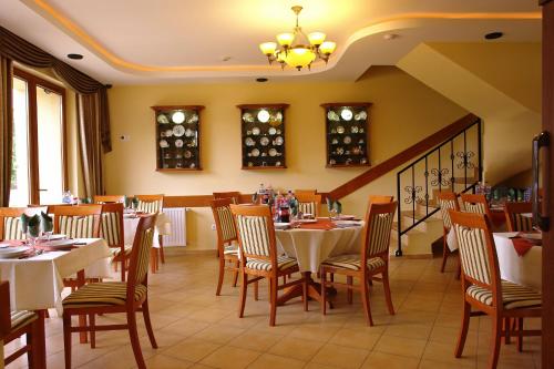 a restaurant with tables and chairs in a room at Szerencsemák Panzió in Kehidakustány