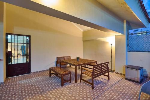 a dining room with a table and two benches at Escape 4BR Penthouse Close to Blue Mall with Private Outdoor Rooftop Terrace in Santo Domingo