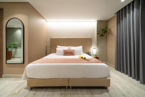 a bedroom with a large bed and a mirror at Eutopiq Hotel in Medellín