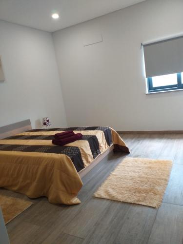 a bedroom with a bed and two rugs on the floor at Retiro da Quinta do Souto in Peso da Régua