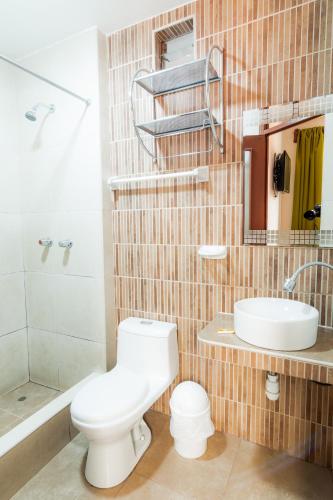 a bathroom with a toilet and a sink and a shower at Hotel San Francisco de Paula Ayacucho in Ayacucho
