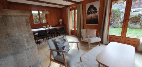 a dining room with a table and chairs and windows at Chalet, Bagnes, Suisse in Le Châble