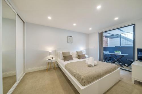 ein weißes Schlafzimmer mit einem Bett und einem Fenster in der Unterkunft Smart Living by Lawsons in Windsor